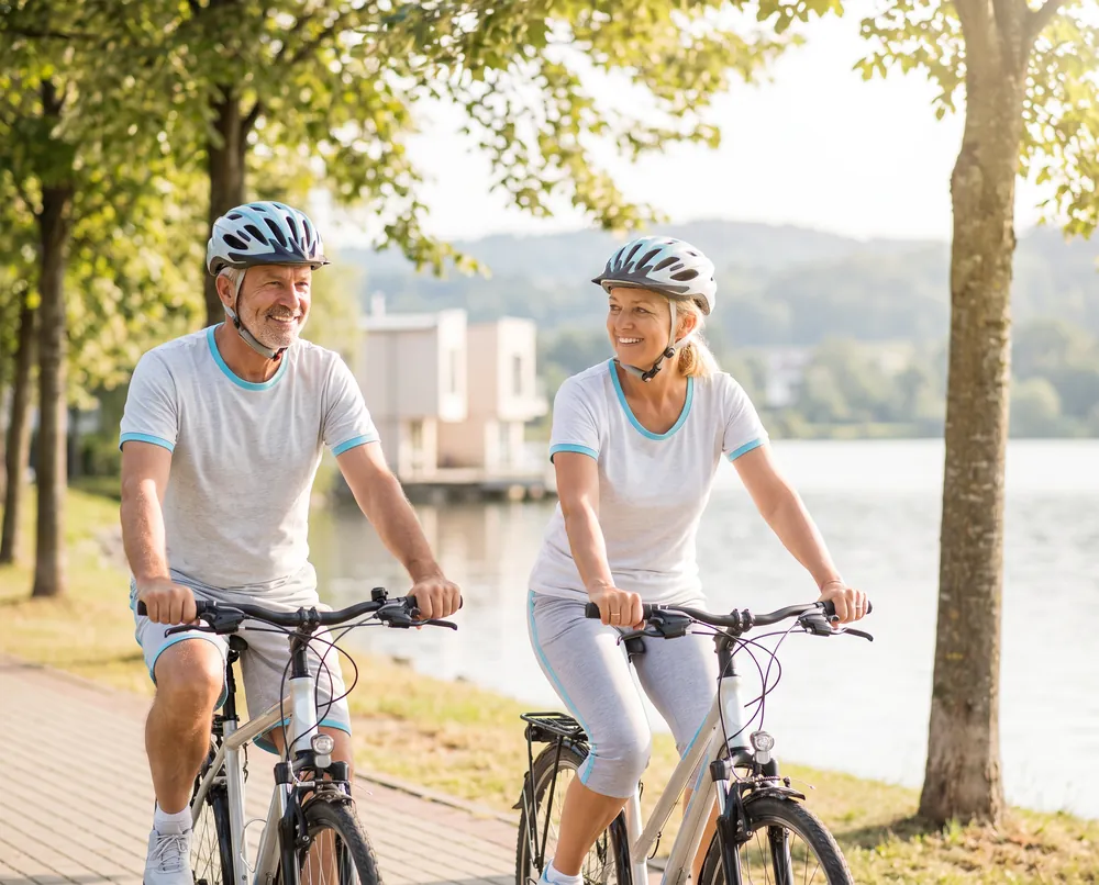 Couple cycling along a lake in the morning